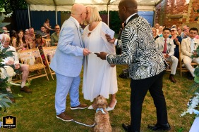 A dog gets involved in the first kiss at Castle Acre in Kings Lynn, Norfolk, adding humor and surprise to the ceremony for everyone watching.
